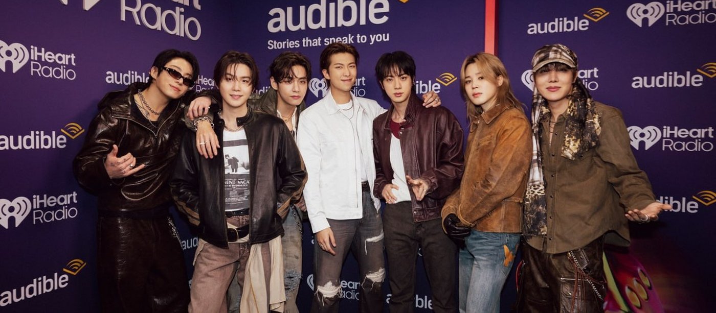 BTS iHeartRadio Music Festival 2026: all seven members posing in front of the iHeartRadio and Audible backdrop