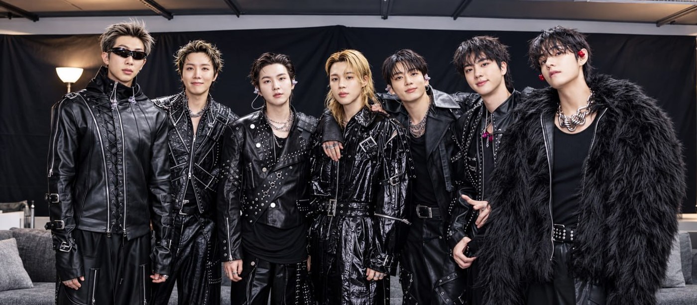 BTS VMAs 2026 winners: the seven members of BTS standing in a row backstage in black leather and studded outfits