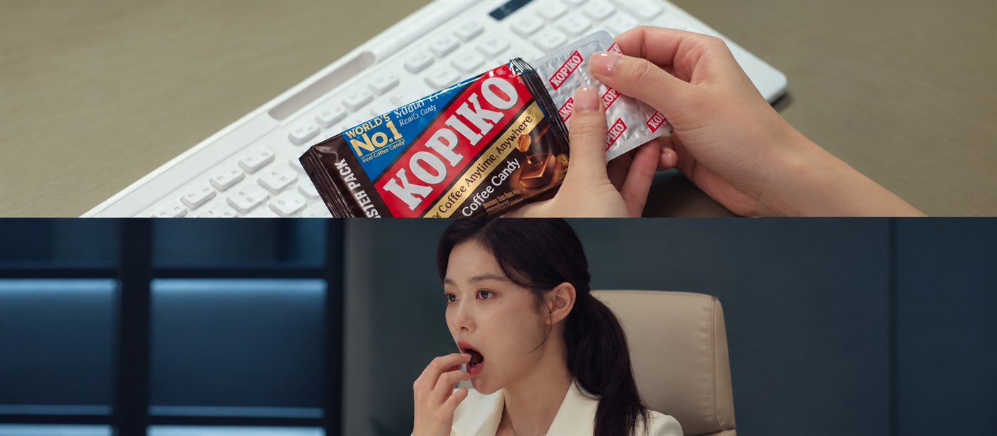 Hands opening a Kopiko coffee-candy blister pack above a woman eating a candy at a desk