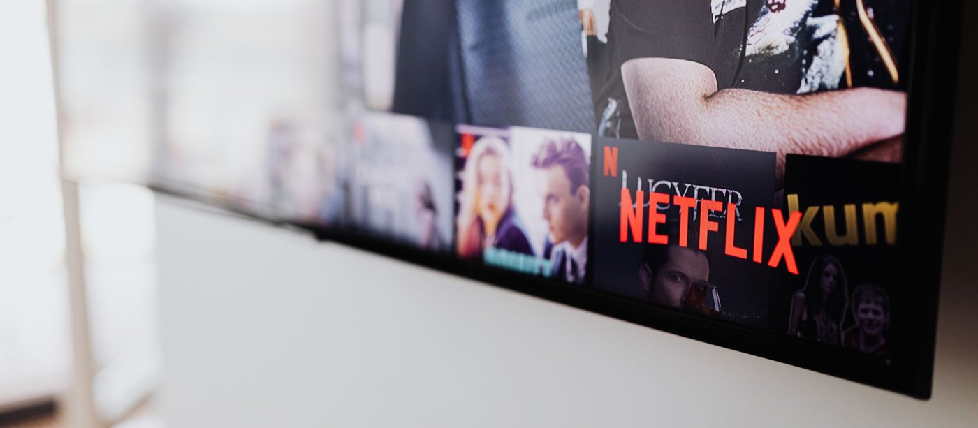 Streaming catalogue rows glowing on a television screen, shot from an angle
